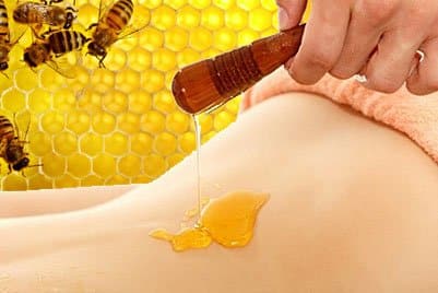 На тело наносится мед для обертывания